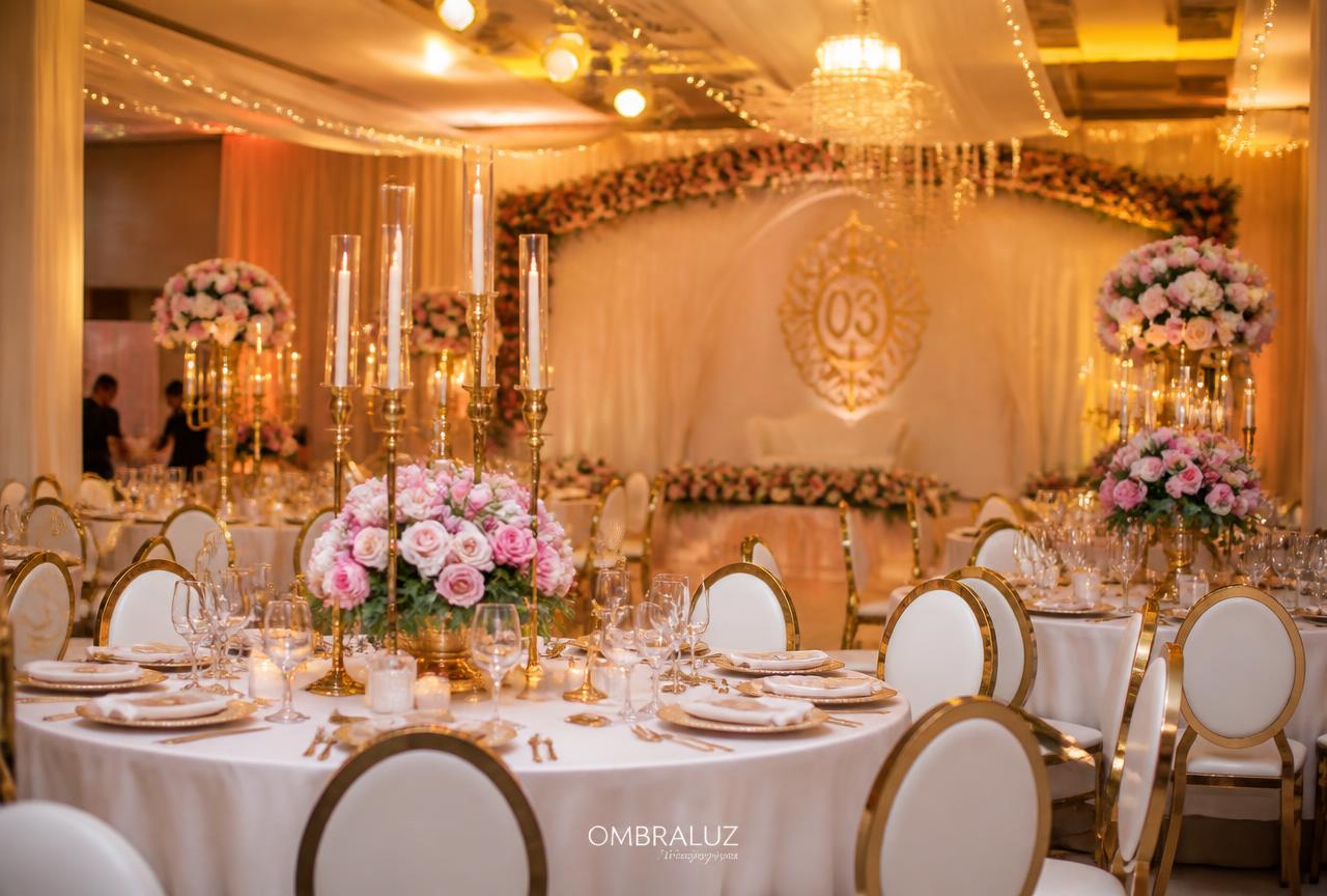 Decoração de casamento com mesas redondas, candelabros dourados e flores cor-de-rosa